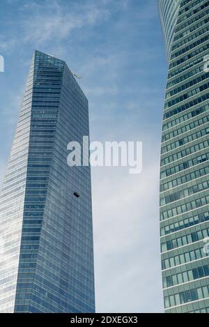 Spagna, Madrid, piattaforma per la pulizia dei finestrini sospesa da un alto grattacielo moderno Foto Stock