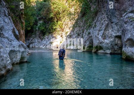 Uomo trekking attraverso il fiume Acheron a Epiro, Grecia Foto Stock