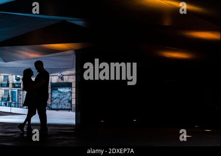 Silhouette romantica coppia abbracciare l'un l'altro mentre si è in piedi alla metropolitana Foto Stock