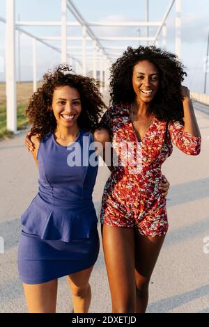 Felici le amiche che camminano il giorno di sole Foto Stock