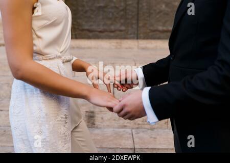 Giovane coppia sposata che tiene le mani dalla chiesa Foto Stock