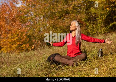 Donna spensierata con le braccia distese che si affaccia sulla montagna alle colline alpine, in Germania Foto Stock