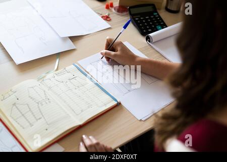 Disegno creativo professionale di sketching femminile su carta in studio Foto Stock