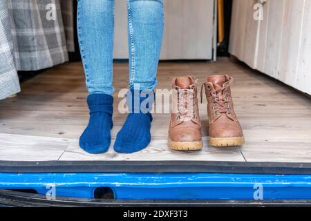 Piedi e stivali femminili alla porta di un camper furgone Foto Stock