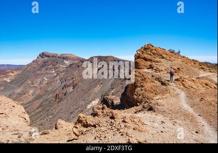 Escursione maschile sulla strada per Sombrero De Chasna durante il giorno di sole, Parco Nazionale Teide, Tenerife, Isole Canarie, Spagna Foto Stock