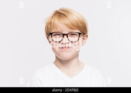 Ragazzo sorridente in occhiali su sfondo bianco Foto Stock