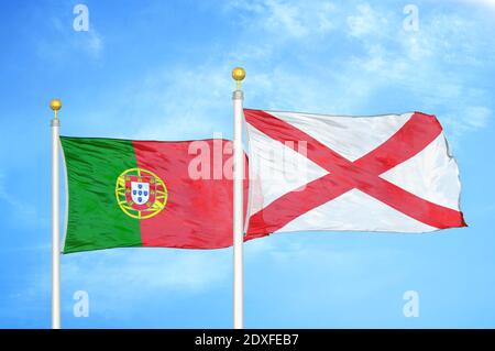 Portogallo e Irlanda del Nord due bandiere su flagpoli e blu cielo Foto Stock