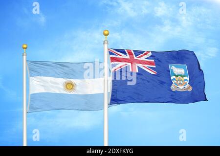 Argentina e Falkland Isole due bandiere su flagpoli e blu cielo Foto Stock