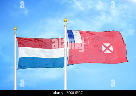 Paesi Bassi e Wallis e Futuna due bandiere su flagpoli e. cielo blu Foto Stock