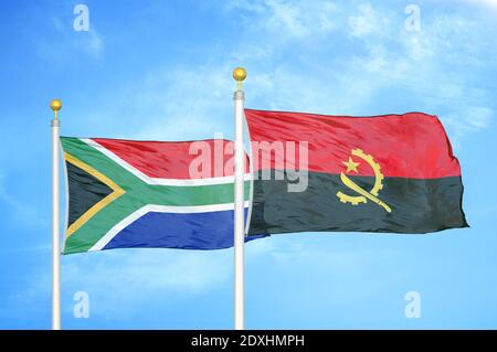 Sudafrica e Angola due bandiere su flagpoli e blu cielo Foto Stock