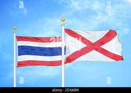 Thailandia e Irlanda del Nord due bandiere su flagpoli e blu cielo Foto Stock