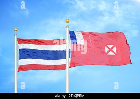 Thailandia e Wallis e Futuna due bandiere su flagpoli e. cielo blu Foto Stock