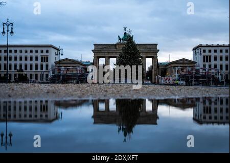 Berlino, Germania. 24 Dic 2020. La porta di Brandeburgo si riflette in una pozza. Credit: Christophe Gateau/dpa/Alamy Live News Foto Stock