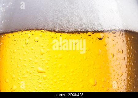Primo piano di un bicchiere di birra freddo con schiuma e gocce. Messa a fuoco selettiva. Foto Stock