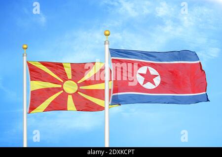 Nord Macedonia e Corea del Nord due bandiere su flagpoli e. cielo blu Foto Stock