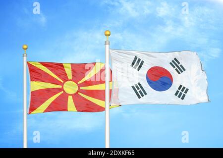 Macedonia del Nord e Corea del Sud due bandiere sui flagpoli e. cielo blu Foto Stock