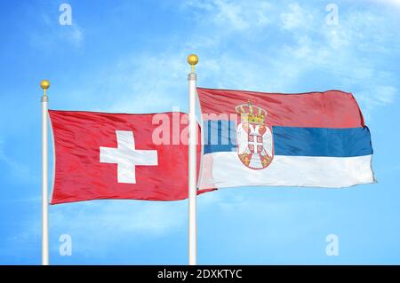 La Svizzera e la Serbia due bandiere su paletti e cielo blu Foto Stock