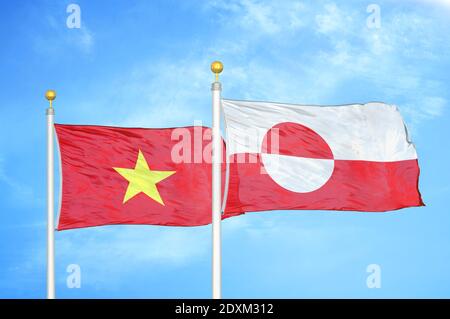 Vietnam e Groenlandia due bandiere su paletti e cielo blu Foto Stock