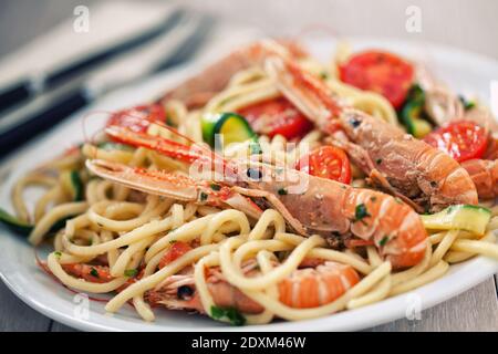 Tagliatelle fatte a mano con gamberi e zucchine in un piatto. Foto Stock