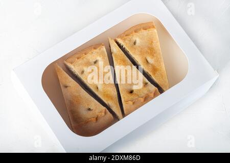 Torta ripiena di funghi su uno sfondo chiaro. Consegna a domicilio. Concetto di festa. Quarantena. Spazio di copia. Foto Stock