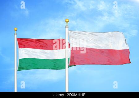 Ungheria e Polonia due bandiere su paletti e blu nuvoloso cielo Foto Stock