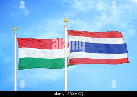 Ungheria e Thailandia due bandiere su paletti e blu nuvoloso cielo Foto Stock