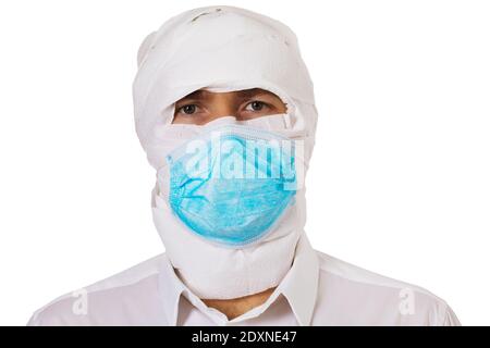 Uomo avvolto in carta igienica e indossando una maschera medica isolata su sfondo bianco. Concetto sul tema della paura di contrarre il coronavirus. Foto Stock