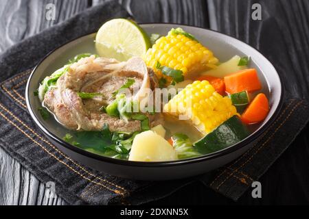 Caldo de Res è una tradizionale zuppa messicana di manzo con scanchi di manzo e scelta di verdure primo piano nel piatto sul tavolo. Orizzontale Foto Stock