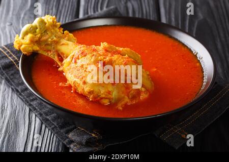 Zuppa di tacchino dell'America centrale in brodo vegetale rosso con spezie da vicino in un recipiente sul tavolo. Orizzontale Foto Stock