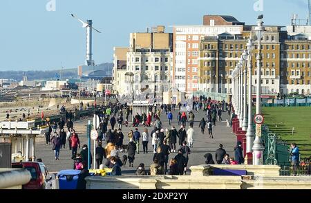 Brighton UK 24 dicembre 2020 - Walkers Godetevi il sole della vigilia di Natale sul lungomare di Hove oggi come un secco incantesimo di tempo è previsto per la maggior parte della Gran Bretagna nel periodo di festa: Credit Simon Dack / Alamy Live News Foto Stock