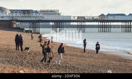 Brighton UK 24 dicembre 2020 - Walkers Godetevi il sole della vigilia di Natale sul lungomare di Brighton oggi come un secco incantesimo di tempo è previsto per la maggior parte della Gran Bretagna nel periodo di festa: Credit Simon Dack / Alamy Live News Foto Stock