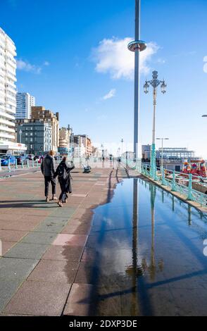 Brighton UK 24 dicembre 2020 - Walkers Godetevi il sole della vigilia di Natale sul lungomare di Brighton oggi come un secco incantesimo di tempo è previsto per la maggior parte della Gran Bretagna nel periodo di festa: Credit Simon Dack / Alamy Live News Foto Stock