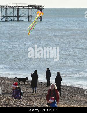 Brighton UK 24 dicembre 2020 - UN kite flyer gode il sole della vigilia di Natale sul lungomare di Brighton oggi come un periodo asciutto di tempo è previsto per la maggior parte della Gran Bretagna nel periodo di festa: Credit Simon Dack / Alamy Live News Foto Stock