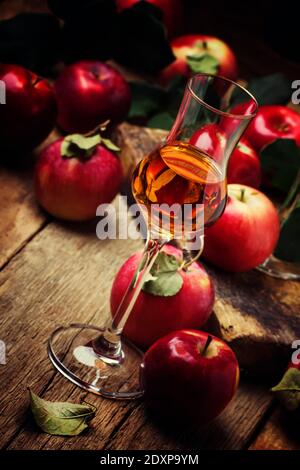 Forte bevanda alcolica dorata di mele, sfondo di legno vintage, fuoco selettivo Foto Stock