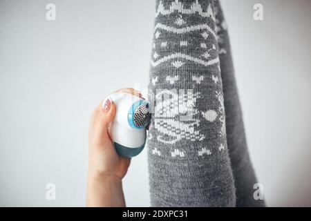 una donna si libera di grumi su leggings di lana, la cura per le leggings Foto Stock
