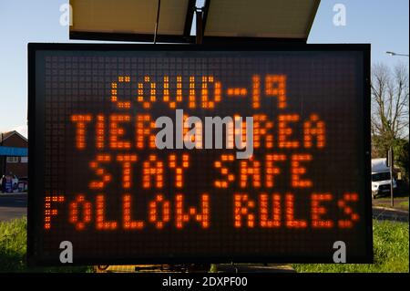 Slough, Berkshire, Regno Unito. 24 dicembre 2020. Un segnale stradale a LED che avverte gli automobilisti che stanno entrando in un'area di Covid-19 Tier 4 a Slough. Più di 3,500 casi positivi di Covid-19 sono stati confermati in tutto il Berkshire nella scorsa settimana. Slough ha avuto il numero più alto a 803 nuovi casi nella settimana scorsa. Dal Boxing Day più contee sono state messe nel Tier 4 in tutto il Regno Unito, come il nuovo ceppo mutante di Covid-19 si diffonde ad un tasso allarmante. Credit: Maureen McLean/Alamy Live News Foto Stock