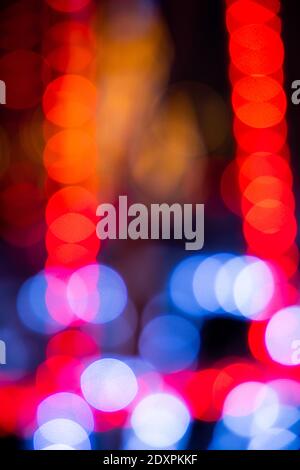 Serata accogliente nella città festosa. Immagine offuscata di luci di Natale scintillanti, ghirlande chiare per Natale e Capodanno a mezzanotte. Foto Stock