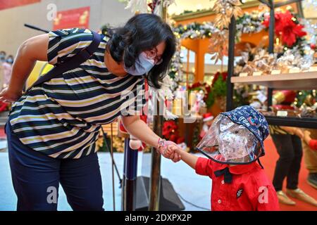 Kuala Lumpur, Malesia. 24 Dic 2020. Le persone che indossano maschere facciali visitano un centro commerciale a Kuala Lumpur, Malesia, 24 dicembre 2020. La Malesia ha segnalato 1,581 nuove infezioni COVID-19, il ministero della salute ha detto giovedì, portando il totale nazionale a 100,318. Credit: Chong Voon Chung/Xinhua/Alamy Live News Foto Stock