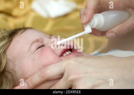 Spray nasale inalante per bambini sul letto di casa Foto Stock