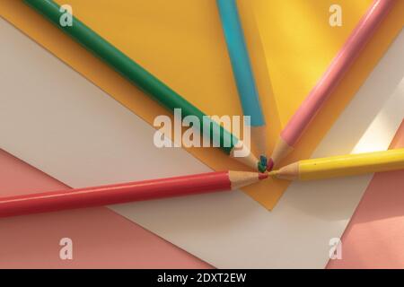Pastelli multicolore su fogli di carta (giallo, bianco e rosa) Foto Stock
