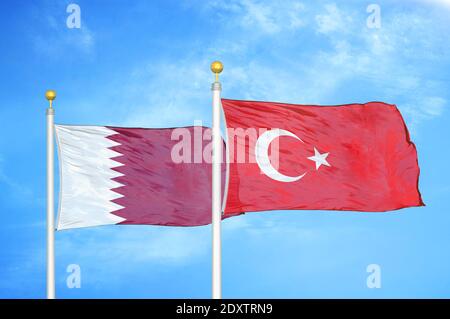 Qatar e Turchia due bandiere su palchi e blu nuvoloso cielo Foto Stock