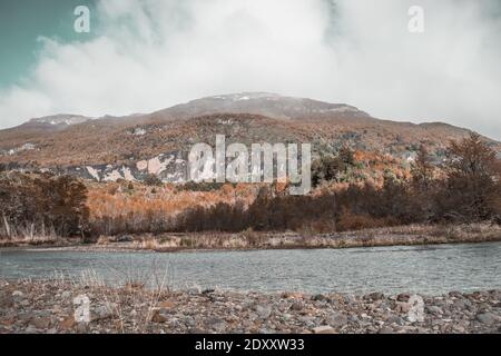 Una scala di grigi di pietre sulla baia di a. fiume circondato da colline in una giornata nuvolosa Foto Stock