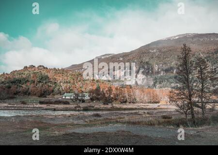 Una scala di grigi di pietre sulla baia di a. fiume circondato da colline in una giornata nuvolosa Foto Stock