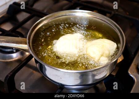 SFINCI tradizionali ciambelle fritte italiane siciliane fritte mentre frittura in verdura olio Foto Stock
