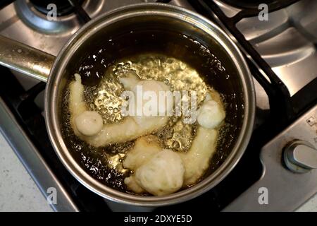 SFINCI tradizionali ciambelle fritte italiane siciliane fritte mentre frittura in verdura olio Foto Stock