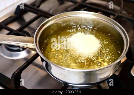 SFINCI tradizionali ciambelle fritte italiane siciliane fritte mentre frittura in verdura olio Foto Stock