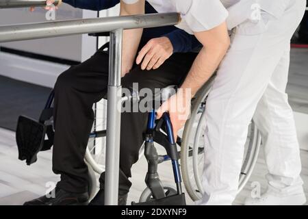 L'uomo anziano è assistito dal fisioterapista nel centro di Rehab. Foto di alta qualità Foto Stock