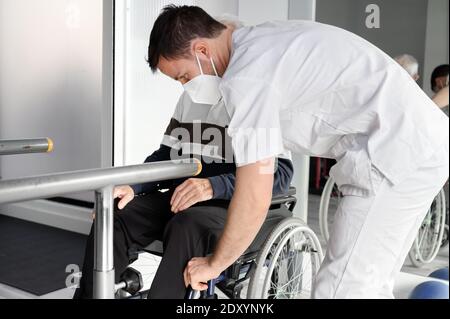 L'uomo anziano è assistito dal fisioterapista nel centro di Rehab. Foto di alta qualità Foto Stock