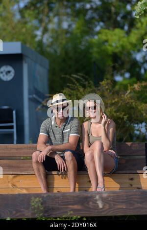 giovane coppia seduta sulla panchina Foto Stock