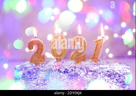 Periodo festivo Felice anno nuovo 2021. Numeri dell'anno 2021 fatto da oro che brucia candele su bokeh festoso sfondo frizzante. Festeggiando il nuovo anno Foto Stock